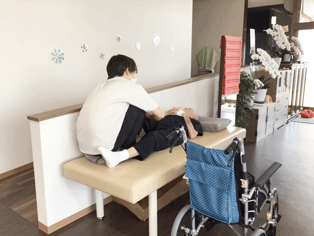 ベッドの上でストレッチをする利用者