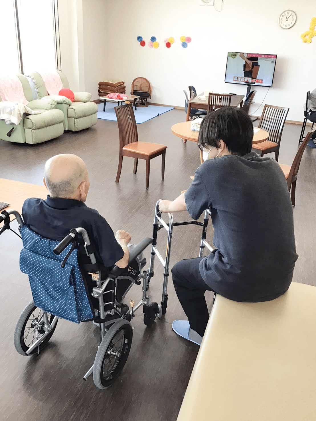 スタッフと会話する車椅子に乗った利用者