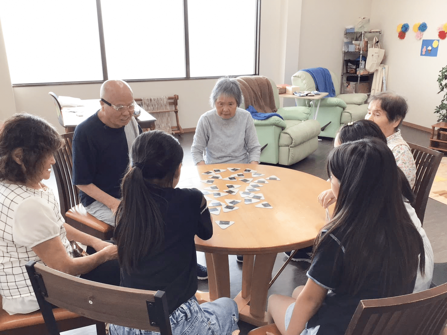 机を囲いゲームする利用者と子どもたち